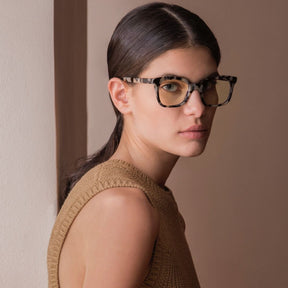 a woman in glasses is looking at the camera 